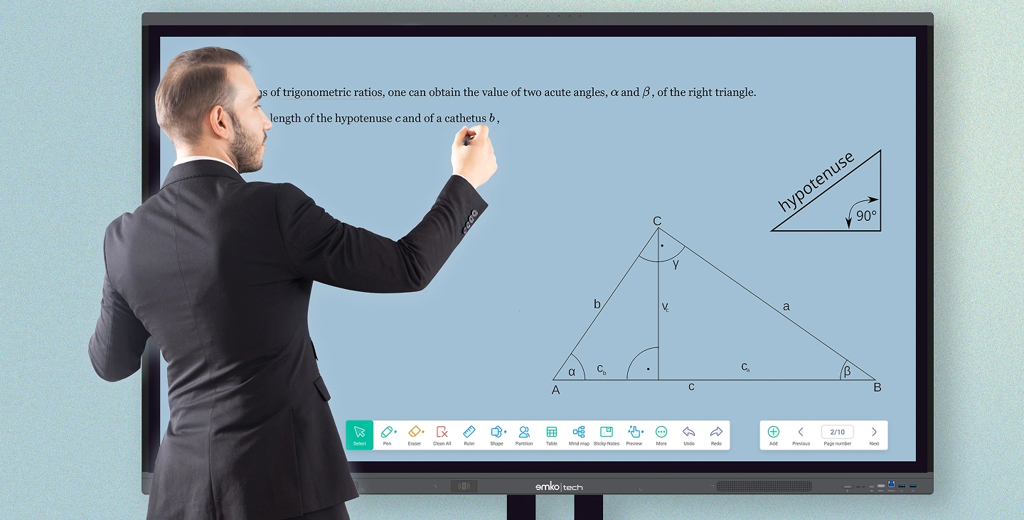 Takım elbiseli bir adam, trigonometrik oranlarla ilgili bir geometri dersini gösteren büyük bir interaktif dokunmatik ekranda yazıyor; altta dik üçgen diyagramları, etiketler ve dijital açıklama araçları görünüyor.