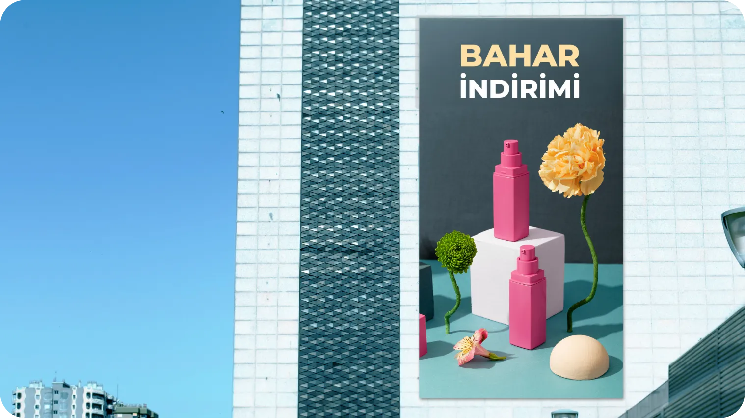 Bir binanın üzerindeki büyük bir reklam panosunda, mavi ve gri bir arka plan üzerinde Bahar İndirimi Türkçe yazısıyla pembe kozmetik şişeleri ve çiçekler yer alıyor. Gökyüzü açık ve mavidir.
